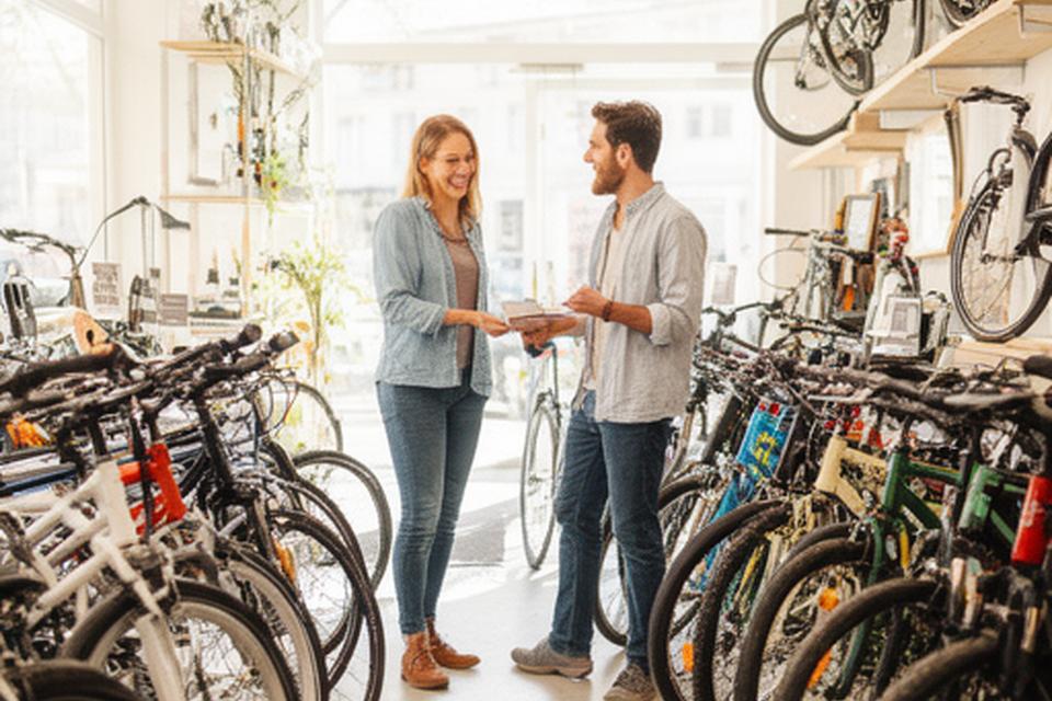 Dois clientes a escolher bicicletas novas dentro da loja com ambiente claro e acolhedor